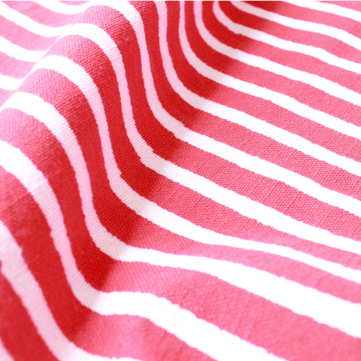 Close up view of a handblock printed fabric in retro red and white stripes from Poeshaq.