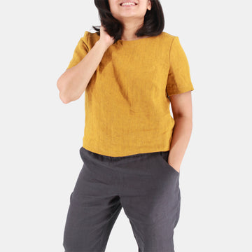Front female model view of Womens Crop Top in Midweight Linen. Color of the top is rich mustard with hints of brown.